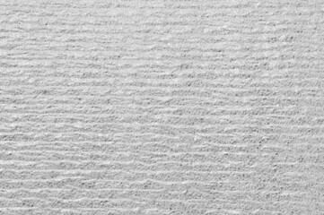 A grey wall with a rough texture. The wall is made of concrete and has a grainy appearance