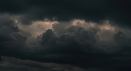 Obraz premium Dramatic dark storm clouds gather with an eerie glow, hinting at impending weather changes and powerful natural forces creating an atmosphere of awe and mystery.