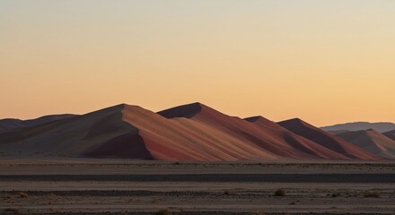 Stunning desert landscape at sunset with rolling sand dunes casting dramatic shadows under a warm, serene sky, evoking peace and vastness for travel and nature themes.