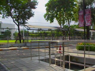 Concrete public walkway and ramp framed by trees, softened in retro tones with film grain.