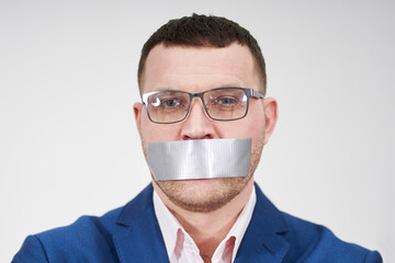 man has a big piece of black industrial tape covering his mouth, silence concept