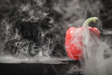 Capsicum bell pepper smoke fume vapour red yellow on black background