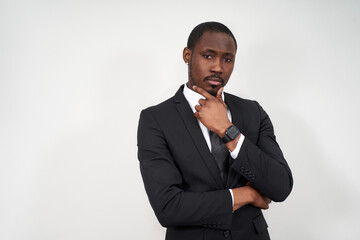 serious African american businessman touching chin wearing black suit over grey background with copy space