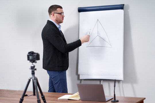 Young video blogger presenting important data on flipchart, online education concept