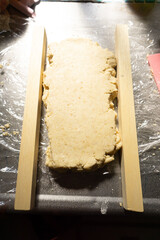 焼き菓子の生地をルーラーで挟んでいる