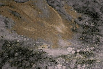 Ethereal abstract background showcasing an experimental fluid art creation with golden swirls and cellular bubble patterns