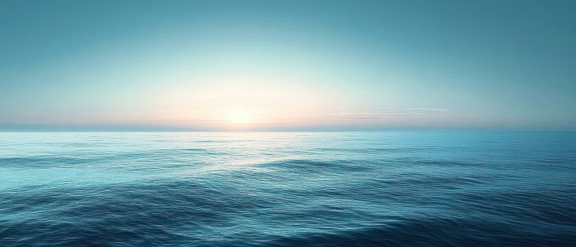 Calm ocean waves under a clear blue sky with the sun rising or setting on the horizon, creating a peaceful and serene atmosphere