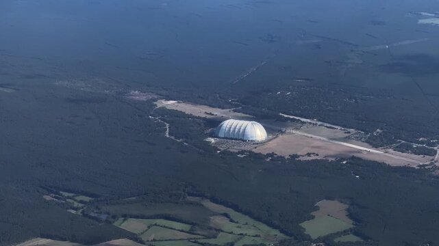 4k aerial video footage, flying along Tropical Islands Resort, a tropical-themed indoor water park in an airship hangar at former Brand-Briesen Airfield. The hall belonged to company "Cargolifter" 