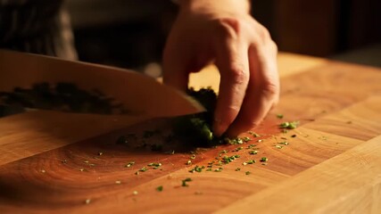 Witness the skillful hands as they chop vibrant green herbs on a rustic wooden board, infusing the air with fresh aromas for a delightful dish. This culinary moment is a celebration of flavor.