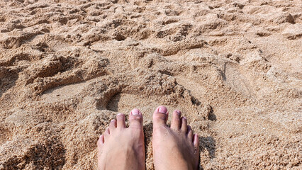 Feet on sandy beach with summer vacation vibe