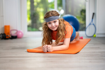 Child practicing fitness in home. Cute little boy doing morning fitness . Young sporty kid...