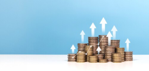 Coins stacked upward with white arrows and a rising graph line, symbolizing financial growth,...