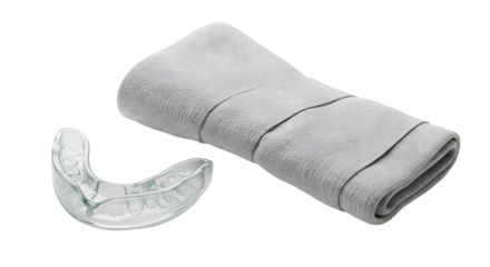SPORT - Clear dental mouthguard with folded gray towel on white background, perfect for sports protection and nighttime teeth grinding