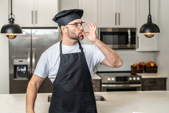 Man chef cooker, baker. Male chefs with sign of perfect food. Chef man cooking, showing sign for delicious. Chef, cook making tasty delicious gesture by kissing fingers. Chefs cook in hat and apron