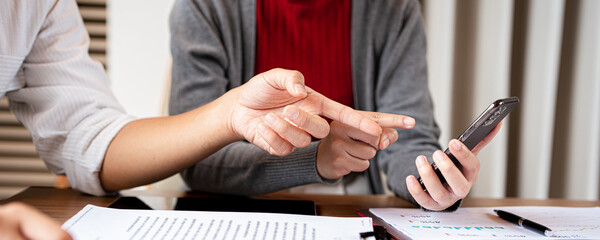 Two asian business persons working together. Businessman brainstorming, having a discussion with...