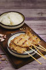 Moo ping grilled pork skewers with sticky rice on a restaurant table