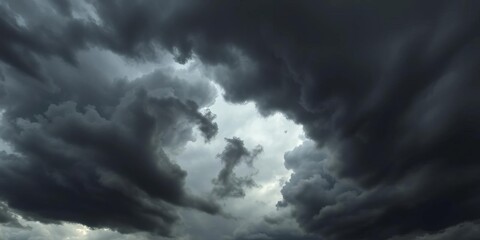 Ominous, swirling dark gray and black storm clouds fill the frame,  black clouds,  sky