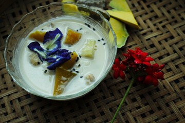 Traditional Thai Pumpkin Dessert in Coconut Milk with Butterfly Pea Flowers and Black Sesame