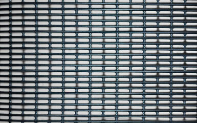 A close-up view of a black metal grill texture, good for industrial background use as a background