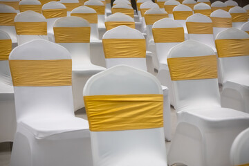 Wedding or party chairs with yellow decorative band.