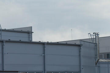 A sleek, modern industrial warehouse under a cloudy sky, showcasing contemporary architecture and structural features.