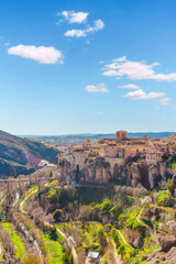 Obraz premium Cuenca houses perched on cliffs overlooking lush valley in spring