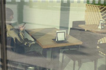 A person is casually sitting at a dining table within a bustling restaurant, focused intently on...