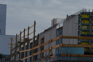 Fototapeta premium A construction site showcasing modern architecture elements against a cloudy sky, highlighting the progress of urban development.