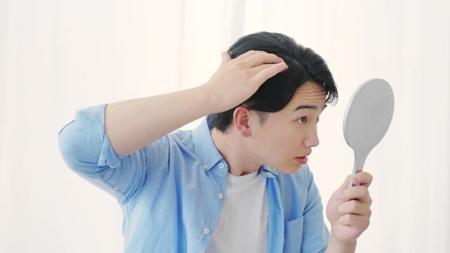 ヘアケアをする若い男性　ビューティイメージ	
