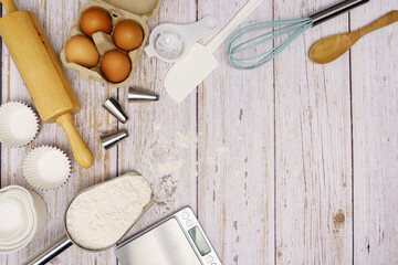 Homemade Dough Recipe (Eggs, flour, milk, sugar) and wooden kneading dough on a wooden table, view from above 