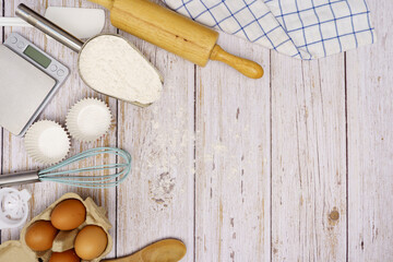 Homemade Dough Recipe (Eggs, flour, milk, sugar) and wooden kneading dough on a wooden table, view from above 