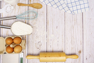 Homemade Dough Recipe (Eggs, flour, milk, sugar) and wooden kneading dough on a wooden table, view from above 