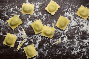 Flat lay composition with raw ravioli on wooden table. Italian pasta