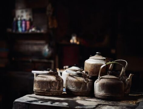 Weathered old kettles resting together in a dim rustic tea house, reflecting tradition and timeworn charm.