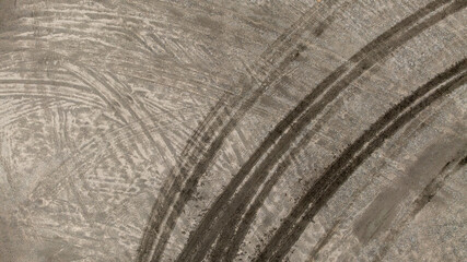 Aerial top view tire track on dirt sand mud, Texture of wet mud road with puddle and Tyre or tire track in countryside, Wheel tyre or tire track on mud, texture and background.