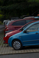 A vibrant display of parked cars in various colors including blue and red, showcasing modern automotive design in an urban setting.