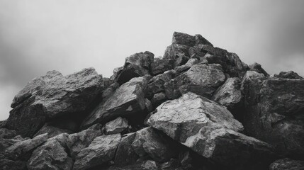A grayscale close-up of a rocky outcrop against a cloudy sky, evoking a sense of wilderness
