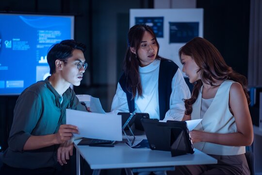 team of financial discussion budget planning, analyzing digital financial data and strategy in a modern office at night