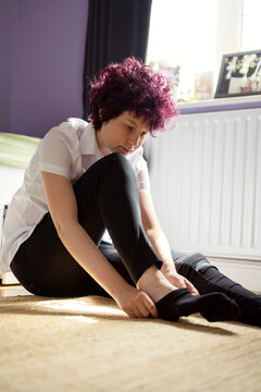 Back to school. teen age girl putting on her socks.