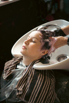 Teen age girl at salon, dyeing her hair, changing hair color