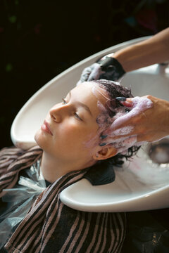 Teen age girl at salon, dyeing her hair, changing hair color