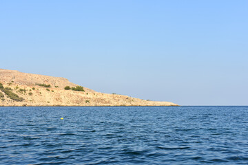Fototapeta premium Panorama of Rhodes Island from the sea. Beautiful sea landscape. Holidays and travel to Greece. Motorboating during vacation. Boat rental. Summer vacation at sea. Tourist boat trip. 