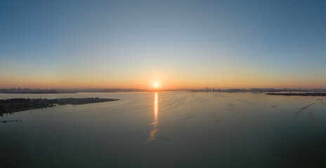 Sunset over Tangxun Lake in Jiangxia, China, casting a golden path across the water's surface.
