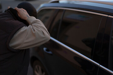 A man is currently attempting to break into a parked car using a long pole, clearly dedicated to...