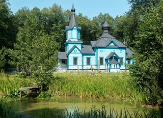 Picturesque, blue orthodox church in Koterka of the Joy of All Who Sorrow Church in the Siemiatycze Deanery, from the perspective of a pond.  