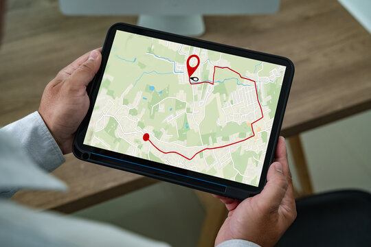 Man holding tablet with navigation app showing GPS map and route, modern digital technology for travel planning, location tracking, transportation, and online navigation guidance.