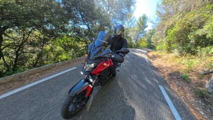 Naklejka premium Motard roulant vite sur une route de campagne