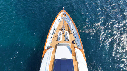 Aerial drone top down photo of luxury yacht with wooden deck anchored in deep blue Aegean sea,...