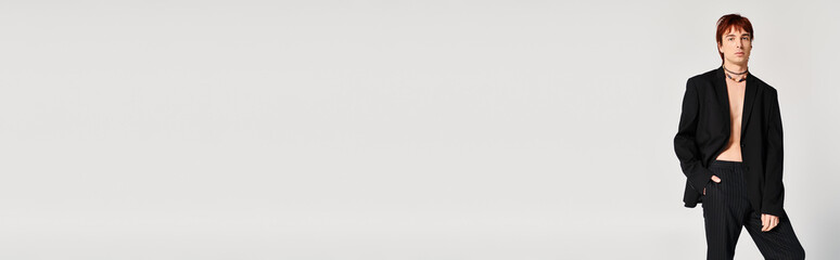 Handsome young man exudes elegance in stylish black attire against a minimalist backdrop