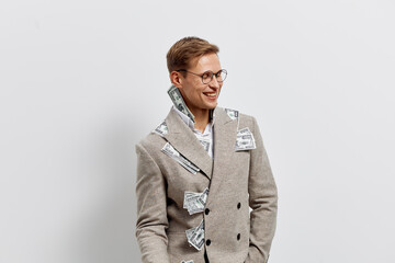 Smiling woman with short brown hair and glasses wearing a stylish plaid coat standing against a...